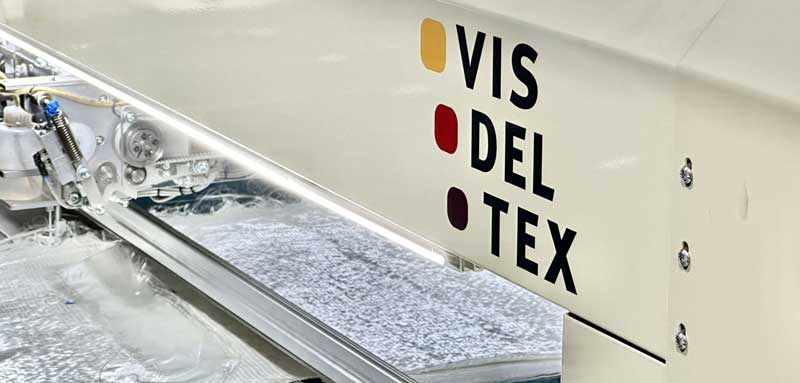 Cabezal de costura reforzado trabajando sobre tejido de fibra de vidrio para la industria de materiales compuestos. En concreto la industria eólica renovable.