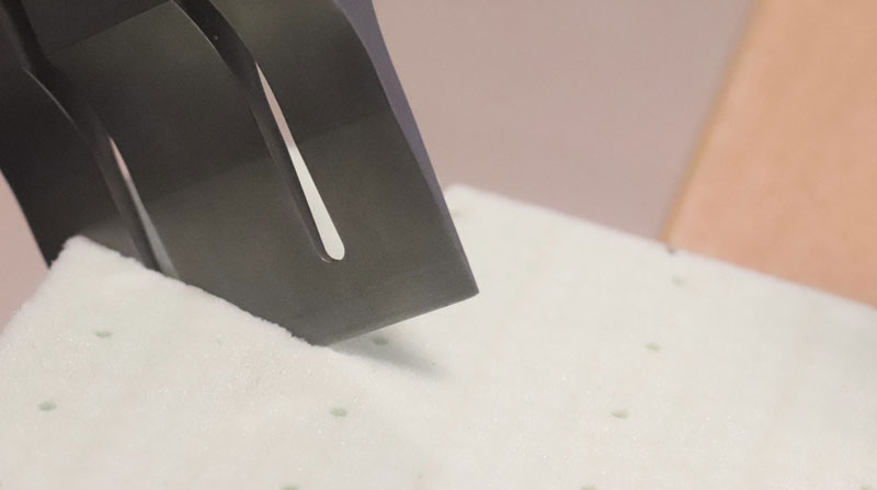 Primer plano de un sonotrodo industrial aplicando soldadura por puntos mediante ultrasonidos en una estructura de material compuesto.